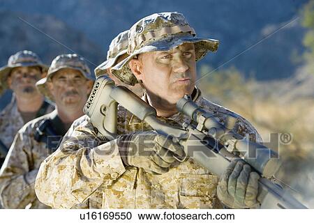 Stock Image - Soldiers on patrol, outdoors. Fotosearch