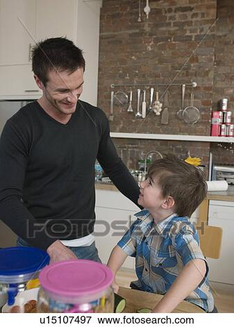 Stock Photo - Son Helping Father in Kitchen. Fotosearch