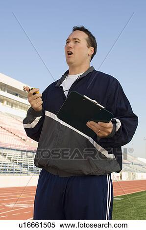 Sports coach looking at stopwatch View Large Photo Image Stock Photography - Sports coach looking at stopwatch. Fotosearch