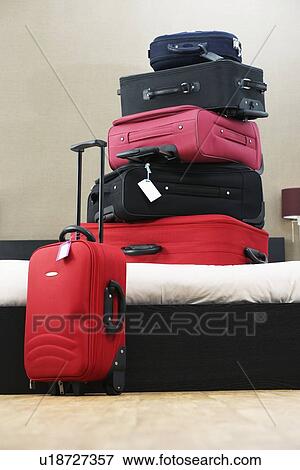 Stack of suitcases on bed View Large Photo Image Stock Photo - Stack of suitcases on bed. Fotosearch