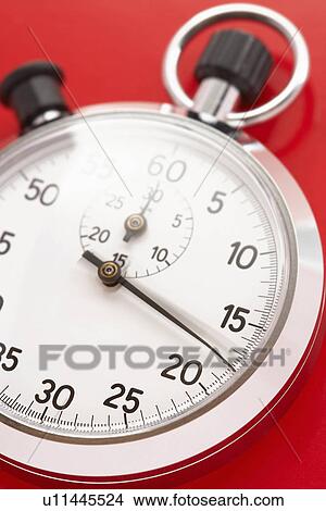 Picture - Stopwatch on red background, studio shot. Fotosearch