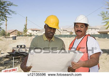 Surveyor and contraction worker at construction site View Large Photo Image Stock Photograph - Surveyor and contraction worker at construction site. Fotosearch