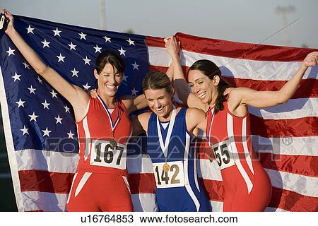 Stock Image - Team of American female athletes celebrating victory. Fotosearch