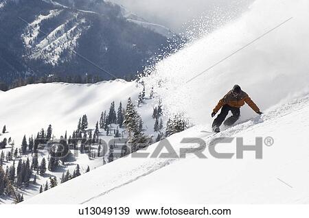 Stock Photo - Teenage boy (16-19) snowboarding down mountain.. Fotosearch