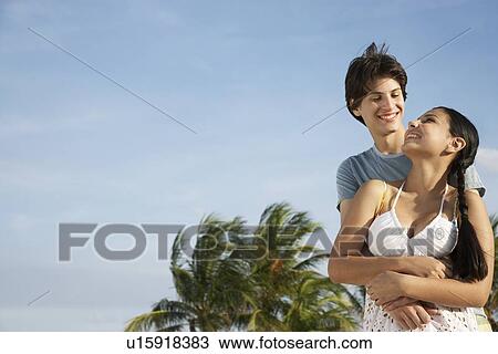 Teenage couple (16-17) embracing on beach View Large Photo Image Stock Image - Teenage couple (16-17) embracing on beach. Fotosearch