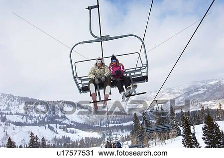 Teenage couple (16-19) wearing skis, sitting on ski lift, low angle view. View Large Photo Image Stock Image - Teenage couple (16-19) wearing skis, sitting on ski lift, low angle view.. Fotosearch