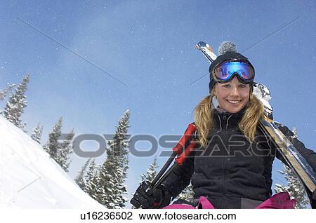 Teenage girl (16-17) holding skis, in front of snow covered hill View Large Photo Image Stock Image - Teenage girl (16-17) holding skis, in front of snow covered hill. Fotosearch