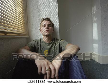 Stock Photography - Teenager (16-18) sitting by window, portrait. Fotosearch
