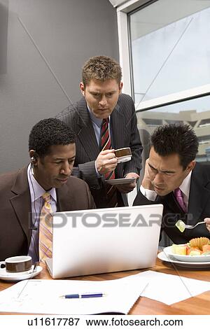 Three business men using laptop in office View Large Photo Image Stock Photo - Three business men using laptop in office. Fotosearch