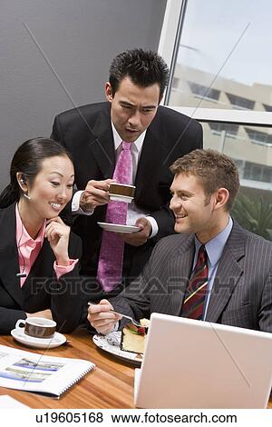 Stock Photo - Three business people having meeting at lunch. Fotosearch