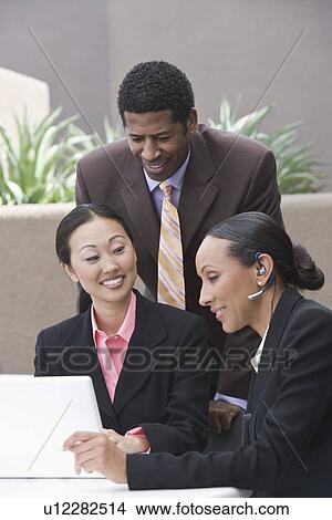 Picture - Three business people having meeting. Fotosearch