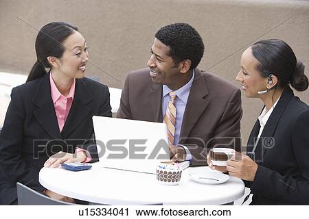 Stock Image - Three business people having meeting. Fotosearch