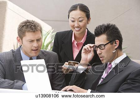 Stock Photograph - Three business people having meeting. Fotosearch