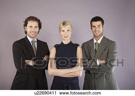 Stock Image - Three business people with arms crossed, portrait. Fotosearch