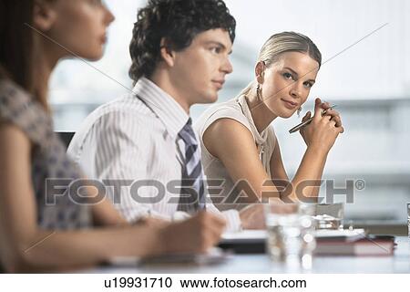 Three businesspeople sitting at business meeting View Large Photo Image Stock Image - Three businesspeople sitting at business meeting. Fotosearch