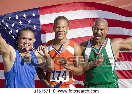 Stock Image - Three male athletes enjoying victory, portrait. Fotosearch
