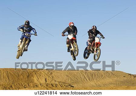 Picture - Three motocross Racers in mid-air. Fotosearch