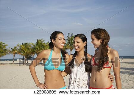 Three teenage girls (16-17) wearing bikinis, standing on beach, portrait View Large Photo Image Stock Photography - Three teenage girls (16-17) wearing bikinis, standing on beach, portrait. Fotosearch