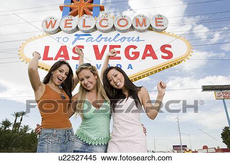 Stock Photography - Three women in front of Las Vegas welcome sign, Nevada, USA. Fotosearch
