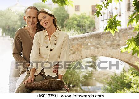Tourist Couple sitting on wall by Stone Bridge, Granada, Spain, portrait View Large Photo Image Stock Image - Tourist Couple sitting on wall by Stone Bridge, Granada, Spain, portrait. Fotosearch
