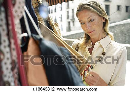 Stock Image - Tourist Shopping for Bags at Stall. Fotosearch