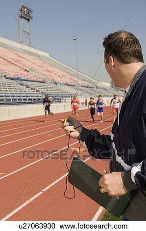 Trainer timing runners on track View Large Photo Image Stock Image - Trainer timing runners on track. Fotosearch