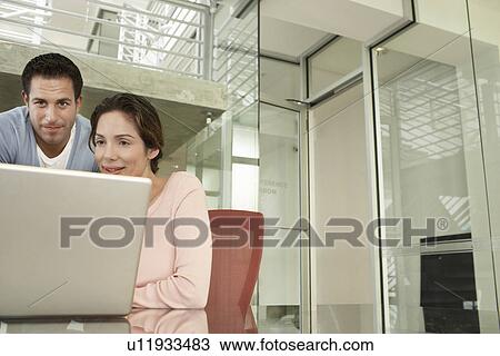 Two business colleagues using laptop in office View Large Photo Image Stock Image - Two business colleagues using laptop in office. Fotosearch