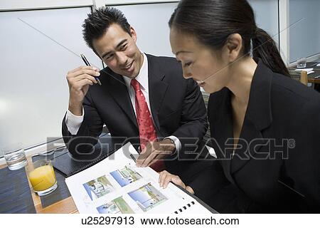 Stock Image - Two business people at business meeting. Fotosearch
