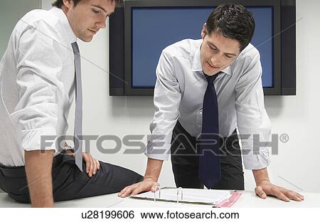 Stock Photograph - Two Businessmen Looking in File Folder. Fotosearch