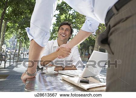 Stock Photo - Two Businessmen Meeting at Sidewalk Cafe. Fotosearch