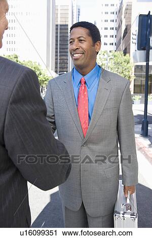 Two businessmen shaking hands, outdoors View Large Photo Image Stock Image - Two businessmen shaking hands, outdoors. Fotosearch