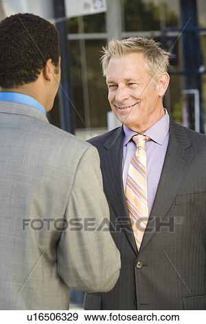 Two businessmen shaking hands, outdoors View Large Photo Image Stock Photo - Two businessmen shaking hands, outdoors. Fotosearch