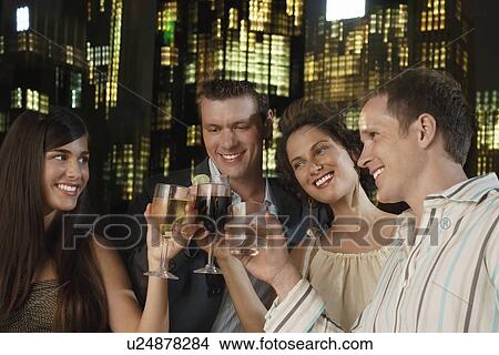 Two elegant couples toasting against city night skyline View Large Photo Image Picture - Two elegant couples toasting against city night skyline. Fotosearch