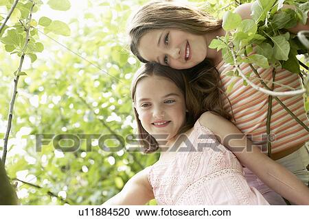 Stock Image - Two girl in backyard, portrait. Fotosearch