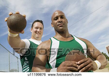 Two male athletes holding shot and discus, portrait View Large Photo Image Stock Photograph - Two male athletes holding shot and discus, portrait. Fotosearch