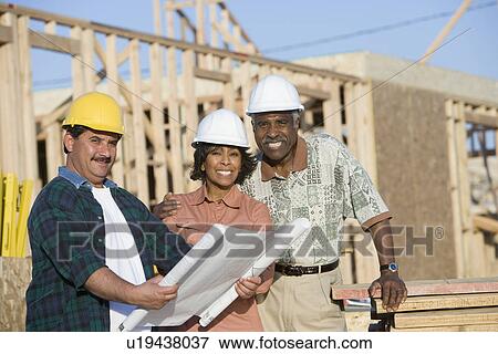 Two men and women with blueprints at construction site, portrait View Large Photo Image Stock Photo - Two men and women with blueprints at construction site, portrait. Fotosearch
