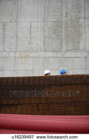 Two men at construction site behind stack of rebar View Large Photo Image Stock Photo - Two men at construction site behind stack of rebar. Fotosearch