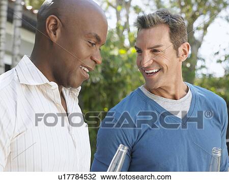 Stock Image - Two men having conversation outdoors. Fotosearch