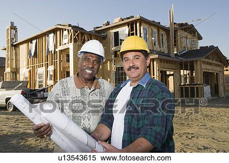 Two men holding blueprints at construction site, portrait View Large Photo Image Stock Photography - Two men holding blueprints at construction site, portrait. Fotosearch