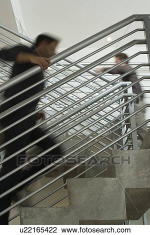 Two office workers walking up stairs View Large Photo Image Stock Image - Two office workers walking up stairs. Fotosearch