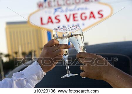 Two people toasting in front of Welcome to Las Vegas sign View Large Photo Image Stock Photograph - Two people toasting in front of Welcome to Las Vegas sign. Fotosearch