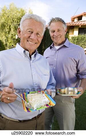 Two senior man eating birthday cake View Large Photo Image Stock Image - Two senior man eating birthday cake. Fotosearch