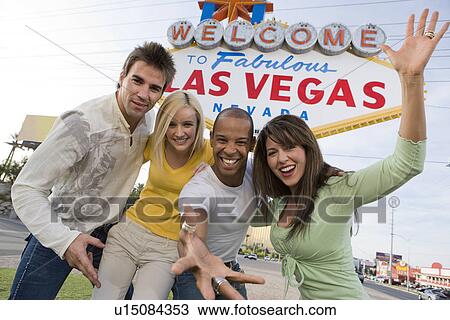 Two women and two men in front of Welcome to Las Vegas sign, group portrait View Large Photo Image Stock Image - Two women and two men in front of Welcome to Las Vegas sign, group portrait. Fotosearch