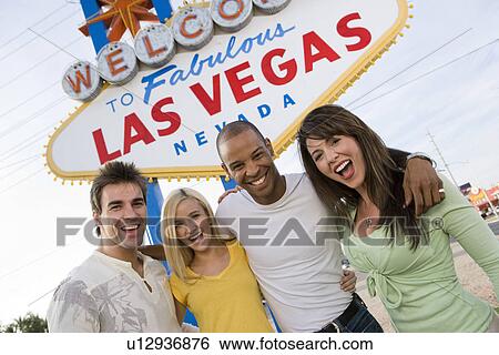 Two women and two men in front of Welcome to Las Vegas sign, group portrait View Large Photo Image Stock Photograph - Two women and two men in front of Welcome to Las Vegas sign, group portrait. Fotosearch