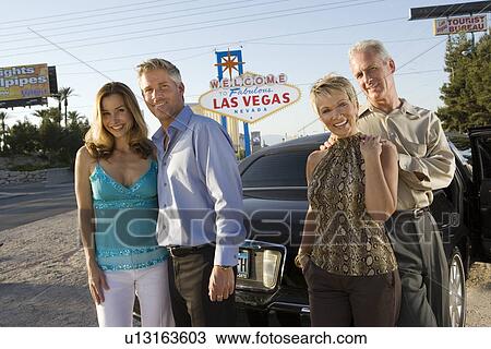 Two women and two men posing in front of Welcome to Las Vegas sign, group portrait View Large Photo Image Stock Image - Two women and two men posing in front of Welcome to Las Vegas sign, group portrait. Fotosearch
