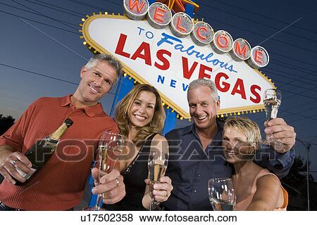 Two women and two men posing in front of Welcome to Las Vegas sign, group portrait. View Large Photo Image Stock Photo - Two women and two men posing in front of Welcome to Las Vegas sign, group portrait.. Fotosearch