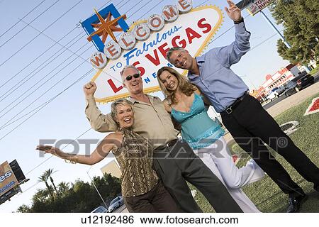 Two women and two men posing in front of Welcome to Las Vegas sign, group portrait View Large Photo Image Stock Photograph - Two women and two men posing in front of Welcome to Las Vegas sign, group portrait. Fotosearch