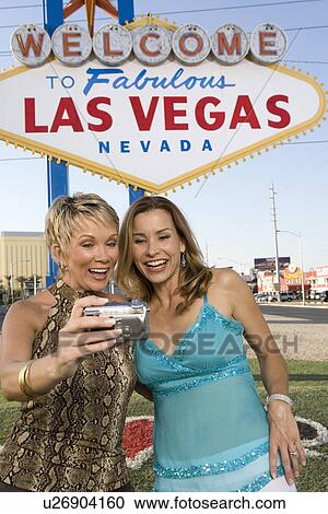 Two women in front of Welcome to Las Vegas sign View Large Photo Image Stock Image - Two women in front of Welcome to Las Vegas sign. Fotosearch