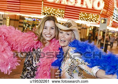 Two women wearing feather boas in front of casino building, portrait View Large Photo Image Stock Image - Two women wearing feather boas in front of casino building, portrait. Fotosearch