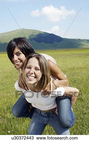 Stock Image - Two Young Women in Meadow. Fotosearch